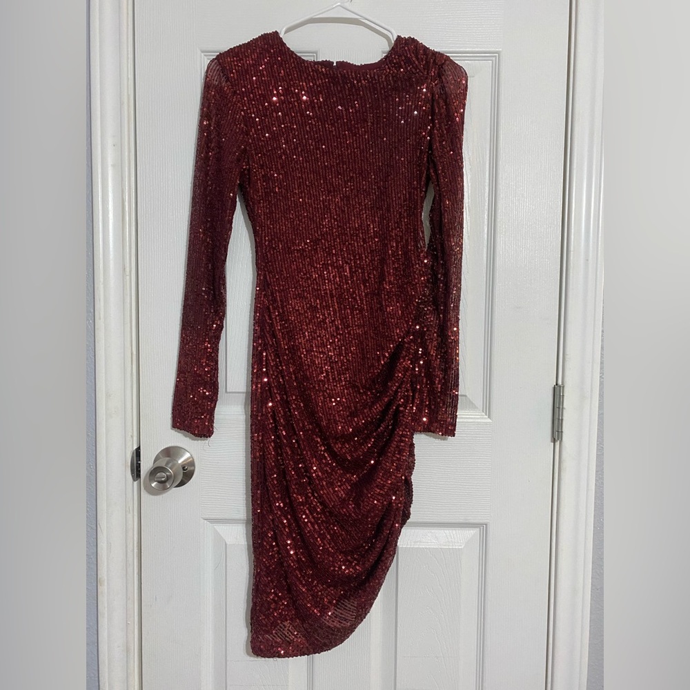 Red dress, has sequins, long sleeve, about knee length, scrunch on the side.